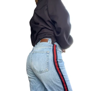 Straight leg jeans med ränder på sidan - Coola straight leg jeans med ränder på båda sidor. Typisk 90-tals modell med fransiga/ avklippta ändar. Höga i midjan och sitter bra på mig men de är lite korta på mig: jag är 166cm  Mått:  Midja: 38 Längd: 93cm