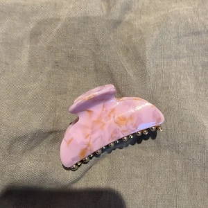 En hårklämma - En hår klämma i rosa, orange och guld. Den är väldig lätt att öppna men den är inte plastig. Ganska liten men skön. Köpte den på glitter typ. Hoppas någon vill köpa🙌🏼💘