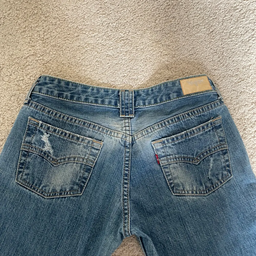 Säljer dessa Levis, utsvängda och lågmidjade jeans 👖 Har en jättefin design på fickorna, och säljer för ett bra pris💗 Midjemåttet rakt över är 38 cm🥰 Pris kan diskuteras vid snabb affär🫶. Jeans & Byxor.