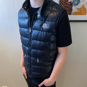 Moncler väst - Moncler gui väst i färgen navy blue. Västen är i storlek 4/L och är köpt från Haiendo. Västen är i grymt bra skick! Kom Dm för mer info och bilder!🙌