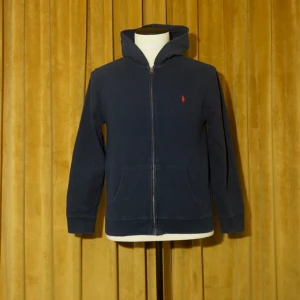 Polo Ralph Lauren Hoodie - Polo Ralph Lauren Hoodie. Tröjan är flitigt använd, därav det låga priset. Barnstorlek XL vilket motsvarar XS-S.
