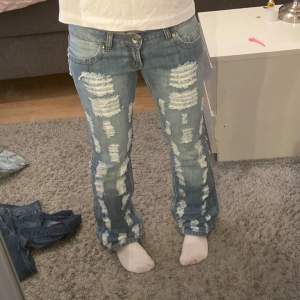 Lågmidjade bootcut jeans med hål Midjemåttet 40  Innerbenslängd 83  Ytterbenslängd 102