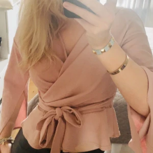 Rosa blus med knyten - Säljer min sååå fina rosa blus med knyte vid midjan! Den är även öppen i armarna så man ser smycken! Bara testad så som ny💗