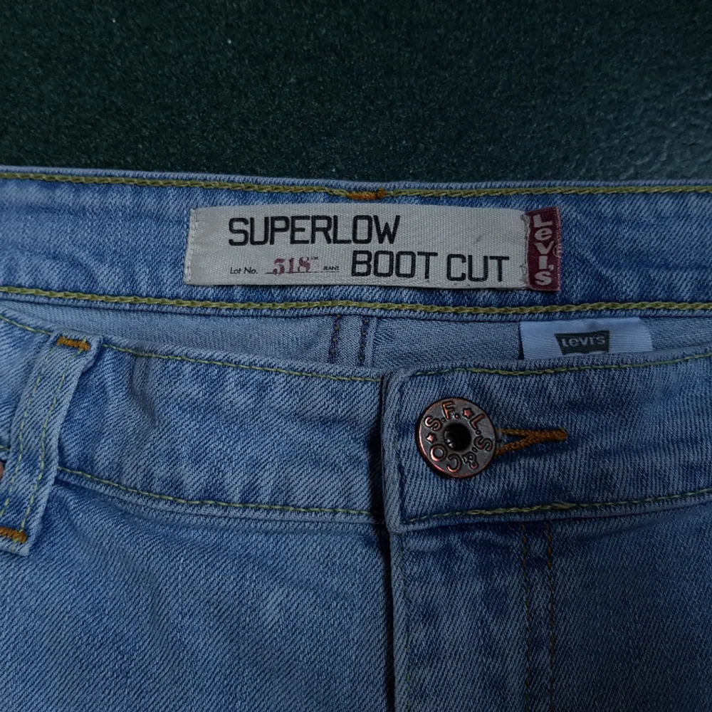 Retro jeans från Levi's i modellen superlow bootcut 518. 🦋 W34L31 midjemått 90cm, innerbensländ 78. Bekväma med stretch. Fina slitningsdetaljer och red tab. Uppsprättade vid benslut. I bra begagnat skick.. Jeans & Byxor.