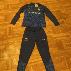 Marseille tracksuit  - En marseille tracksuit som jag fick men passade inte. Aldrig använd lappen sitter kvar. Passar också M Skriv för mer info