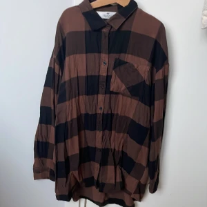 Brun och svart rutig skjorta  - Skjortan är tunn och lätt  Den har inte använts så mycket men den behöver bara strykas   