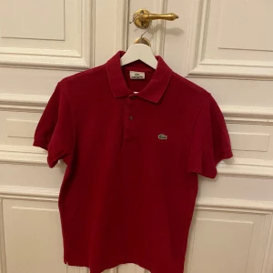 Lacoste  - Lacoste piké färg röd stl M/L i jätte fint skick 