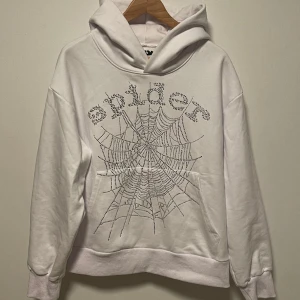 Sp5der Hoodie Vit, Sz Medium - En extremt snygg hoodie från young thugs märke Sp5der. Rhinestonesen är alla på och tröjan har använts ytterst lite då jag varit rädd om den.  Nyskick från ett djur och rökfritt hem 