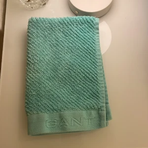 Badrums kit - En grön badrummets matta, till det får man även två handdukar. En lite mindre, och den andra vanlig storlek, den lilla är helt turkos, och den stora är både mörkblå,turkos,gul,vit och ljusblå❤️