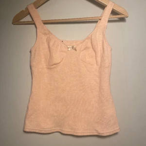 Söt rosa ribbat linne - Aldrig använt, jättefin till sommaren/våren. Ribbad i rosa/ljusrosa med en rosett där fram. Passar på storlek S och XS💕 Inga hål eller defekter.