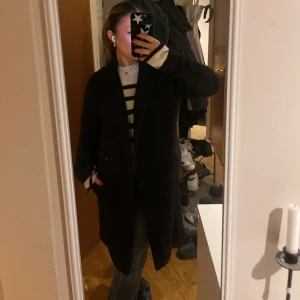 Lång svart kappa - Snygg kappa från Carin Wester som jag ej använder längre. Fortfarande i bra skick. (Kostade 1000kr, säljer för hälften av priset!)