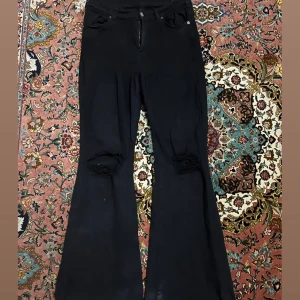 Utsvängda jeans  - Säljer ett par utsvängda jeans från Salt med hål på knäna. Använd ett par gånger. Stretchiga är dom vid midja