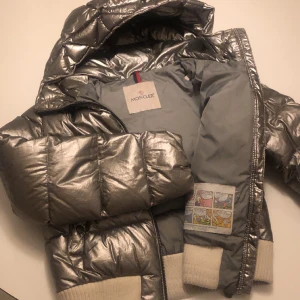 Monclerjacka stl 140 - Fin äkta Monclerjacka i silver. Bra skick och inga defekter. Monclerloggan scannar vilket bevisar äktheten. 