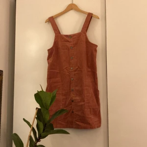 Klänning i rosa manchester - Snygg klänning med knappar och två stora fickor. Storlek 38. Bra skick!