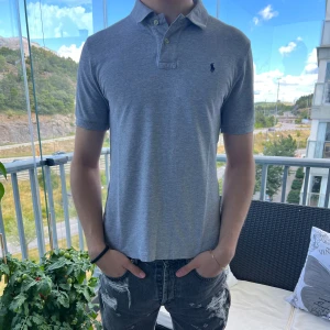 Ralph Lauren Piké Grå - Säljer denna gråa Ralph Lauren Piké i 10/10 skick, inga defekter. Storlek L i barnstorlek men sitter som S/M. För fler bilder eller eventuella frågor, hör av dig privat. Modellen på bilden är 180cm