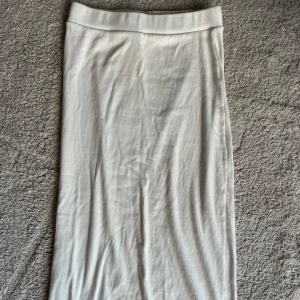 Vit kjol från Zara - Vit kjol från Zara, knälång.  Ribbad med en bred mudd i midjan. Storlek M 
