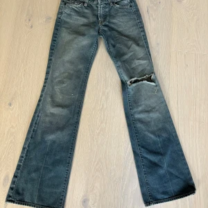 Lågmidjade utsvängda jeans med hål - Säljer mina supersnygga jeans från 7 all man kind då de tyvärr inte kommer till användning 