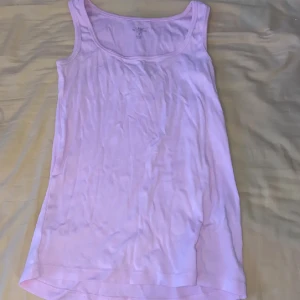 Ljusrosa linnetopp - En enkel och bekväm ljusrosa linnetopp. Toppen är ärmlös och har en rund halsringning.