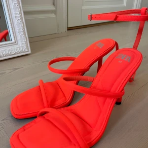 Orangea klackskor från Zara - Ett par oanvända orangea klackar från Zara köpta för 2 år sedan. 10 cm hög klack och i storlek 40, men de är lite mindre i storleken.