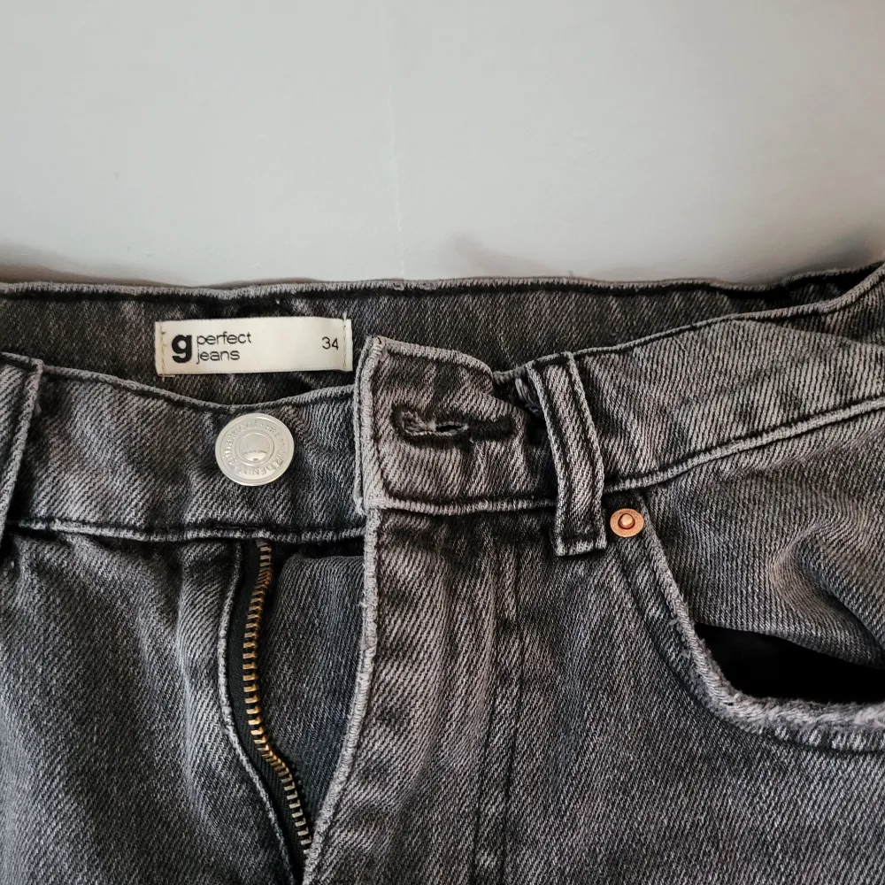 Ett par grå jeans från märket Perfect Jeans. Byxorna har en klassisk fyraficksdesign och stängs med dragkedja och knapp. De har en rak passform och är tillverkade i ett slitstarkt material.. Jeans & Byxor.