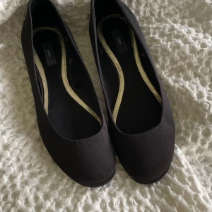 Svarta ballerinaskor - Ballerinaskor, svarta från Zara. Står strl 40 men passar en 39. Hård sula under vilket gör att de är lite ordentligare. Använt en gång, bra skick!!