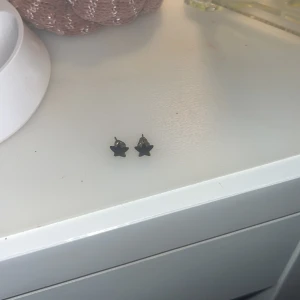 Svarta stjärnörhängen  - Svarta stjärnörhängen. Vet ej vart de är ifrån. Använda. Ena stjärnan har blivit lite sne (bild 2), men annars bra skick. Tror inte det är äkta silver p.g.a lite missfärgade på stopplupparna men jag som är allergisk mot nickel har inte fått utslag. 💕