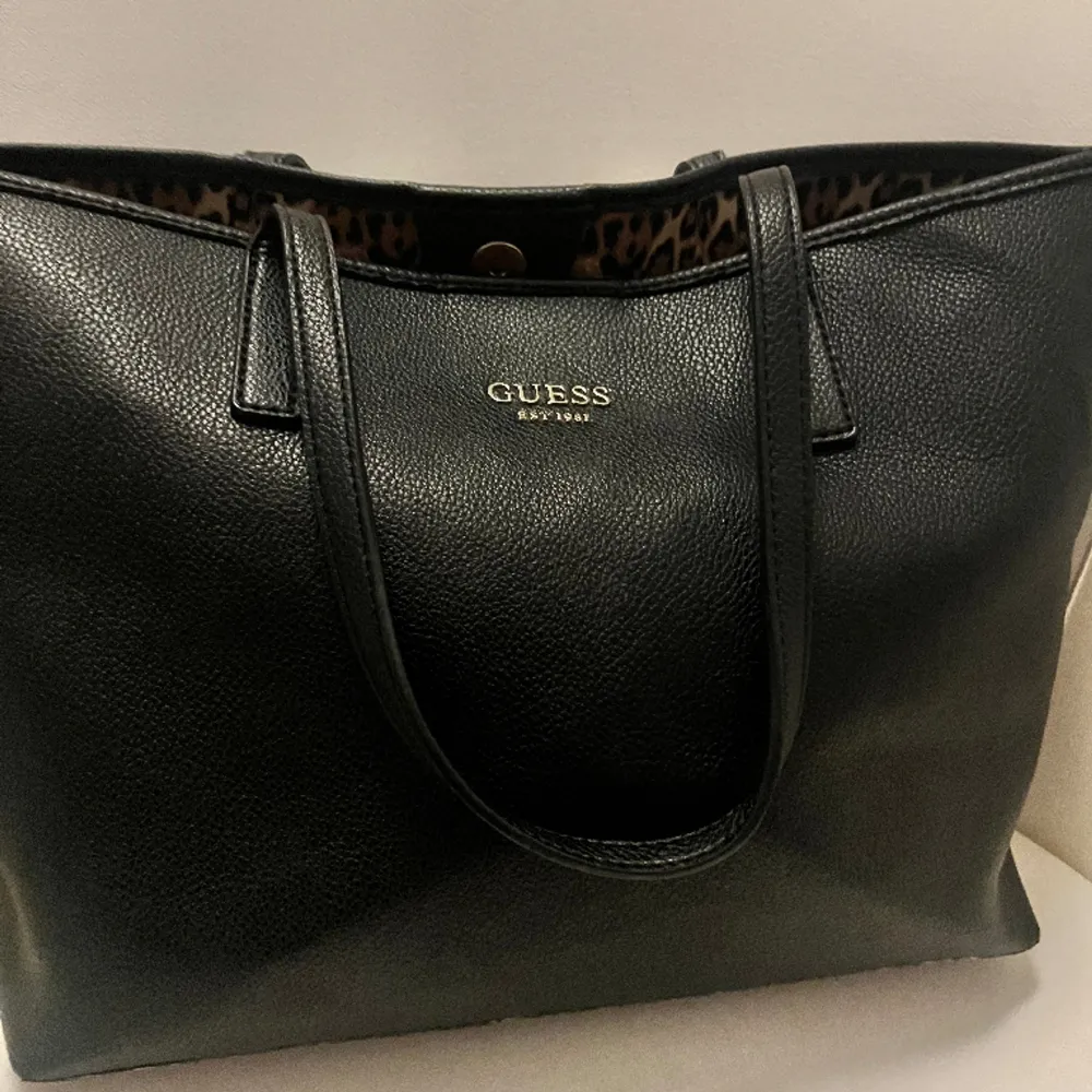 En jättefin svart väska från Guess. Den är i bra skick. Köpte den för 1250kr men säljer den för 400kr. Väskor.