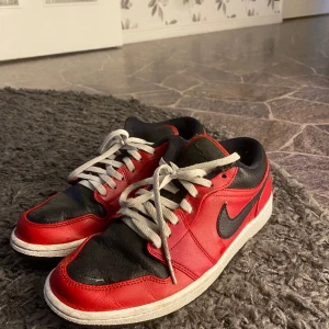 Jordan 1 lows red gym - Säljer ett par Jordan 1 lows, Slitna (se på bild) Förutom märkerna är de i bra skick, tyvärr inte rätt skosnöre på utan det ska vara ett par svarta. Strl: 42 (US 9)