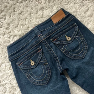 True religion jeans lowwaist bootcut  - True religion jeans, lågmidjade med lätt bootcut. Bra skick, Inga defekter! Innerbenslängd:72 midjemått:35 + stretch. Säljer billigt då jag vill bli av med de snabbt. Vill du köpa trycker du på köp nu. Jag postar inom 24h