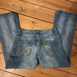 Lågmidjade jeans - Lågmidjade jeans med slitningar. Jag på bilderna är 165. Innerben: 71 Rakt över midjan: 39