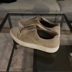 SNEAKERS - Väldigt eleganta & snygga skor i en fin beige färg. Skorna har som en mini dragkedja framtill. Använda fåtal gånger. 