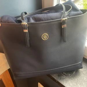 Tommy Hilfiger Väska - Hej, Tommy Hilfiger Väska, Använd 2 gånger och är som en ny, inga defekter eller skador. Köpt på Boozt och självklart äkta. Pris kan diskuteras!