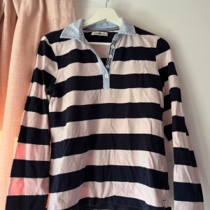 Randig rugbytröja  - Jättefin rugbytröja, använd några gånger. Randig i rosa och mörkblå. Storlek s, perfekt nu till sommaren/sen sommar