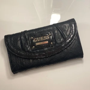 Guess plånbok - Supersnygg plånbok som även kan användas som liten väska i handen vid festligare tillfällen 💘Jättebra skick då den knappt är använd. Tveka inte på att höra av dig vid minsta fundering! 