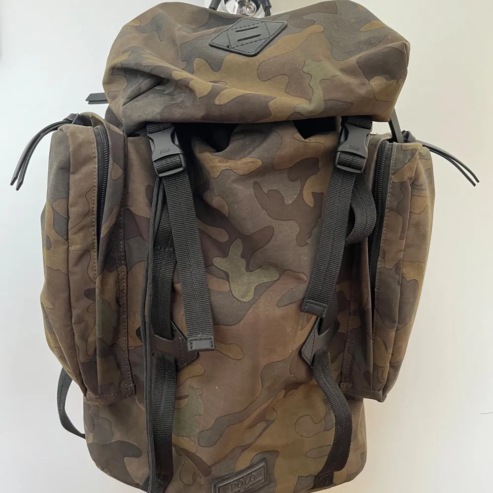  Sällsynt ryggsäck camouflage från Ralph Lauren i mycket god skick, små tecken på användning (vänlig se bilder).   Mått: Längd/höjd ca 45 cm Bredd 35-40 cm Djup 15-20 cm  Material: canvas och detaljer i läder och polyester  Väskan kommer från ett dju. Väskor.