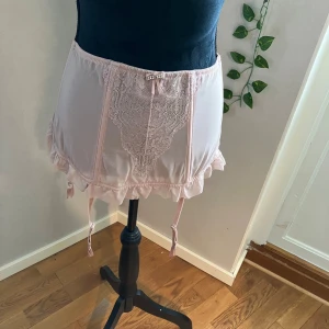 Korsett  - Helt ny med prislapp, aldrig använd, från Italy, strl M, liten i storleken och är mer strl XS/S. Hammalrosa färg, med spets/spetsdetaljer.