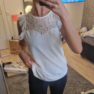 Spetstopp - Supersöt topp med spets runt hela överdelen. Har en knapp bak med ett en öggla under som fin detalj. Resten av tröjan har ett lyxigt lite glansigt material. Superbra att klä upp men även ha i vardagen. Skulle säga att den kan passa både XS och S🤍