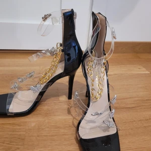 Fest skor. - Helt oanvända festskor i storlek 37.  Guldkedja som går omlott över foten. 