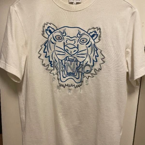 Kenzo t-shirt  - Jätte snygg och clean kenzo t-shirt. Använd ett fåtal gånger nästan som ny. Storlek s men sitter om m-L. Nypris 1500kr. Köpt på selfridges i London. 