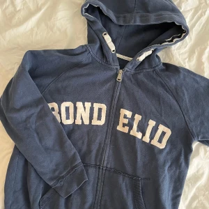 Kofta - Blå liten kofta från Bondelid. Bra kvalitet med metall-dragkedja. Passar perfekt till lowwaisted jeans då den inte är så lång/stor.