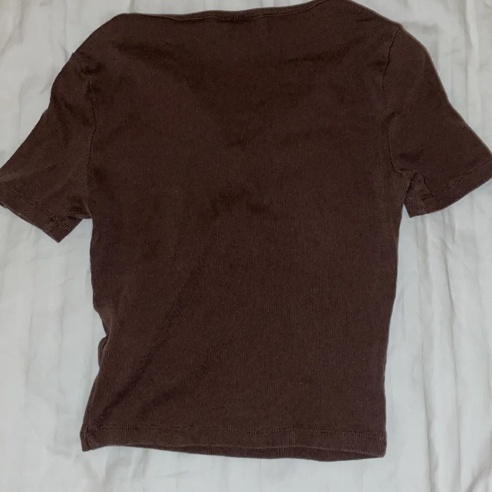 En brun färgad topp från Gina Tricot i storlek XS, köpt förra året. Den har använts många gånger men den har inte slitits, färgen har blivit lite urtvättad men den ser fortfarande bra ut. Säljer då den ej används längre . T-shirts.