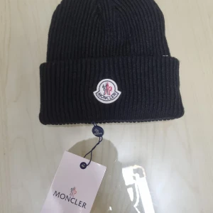 Moncler mössa  - Hej  Säljer den eftersom jag inte gillar mössor men den är helt ny och oanvänd 