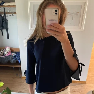 Blus med rosetter - Blus med 3/4 ärm och rosetter