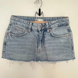 Gina Tricot jeanskjol 32 - Snygg Gina Tricot jeans minikjol strl 32. Kjolen är extra kortad. 100% bomull.
