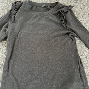 Svart tröja  - Säljer min svarta tröja med volang på ärmarna. Den är för kort och liten sliten och därav priset. Skriv för fler bilder💕