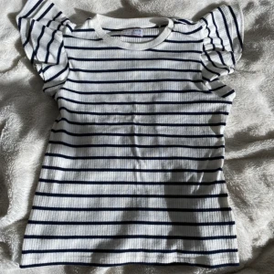 Supersöt sommar blus🌟 - Säljer denna supersöta sommar toppen med volanger köpt på Lindex, och slutsåld från hemsidan.😍Toppen är ribbad och otroligt skön och i superfint skick då den använts ett fåtal gånger. Passar både uppklädd som nedklädd i alla tillfällen.✨🫶🏻