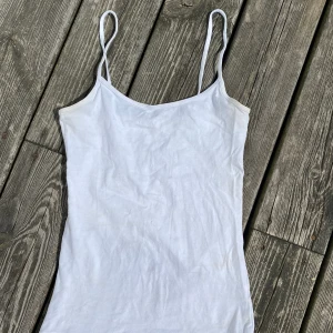 vitt linne med smala axelband  - vitt linne med smala axelband  missfärgning förekommer, se bild 