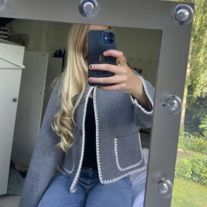 Grå kofta från Ryvls  - Den är grå med vita detaljer och mörkgråa knappar. Jag har använt den 2 gånger 