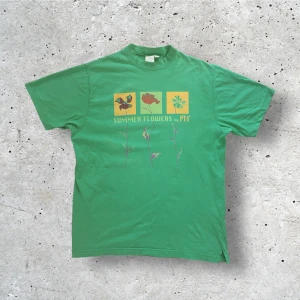 Vintage grön t-shirt med tryck på - En cool vintage tröja med tryck på i fint skick!!! Från märket PTA, i storlek L. Passformen känns som M. Mått: längd 72 cm, bröstkorg 53 cm, axelbredd 45 cm, hemm 55 cm