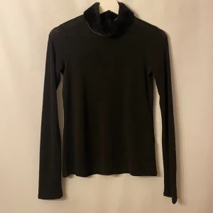 Topp med pälskrage - Svart lite genomskinlig topp med pälskrage. Märke: Zara. Storlek: M 